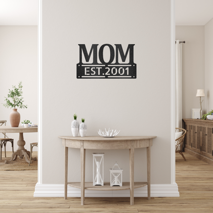 scripted MOM plaque with personalized  date of motherhood, powder coated black finish metal wall decor, hanging on a creamy white wall over a small table | Home Accent Studio