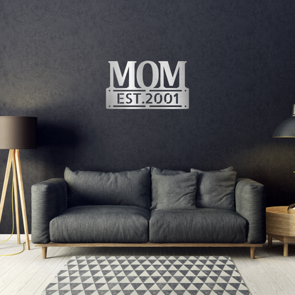 scripted MOM plaque with personalized  date of motherhood, powder coated silver finish metal wall decor, hanging on a black accent wall over a black sofa | Home Accent Studio