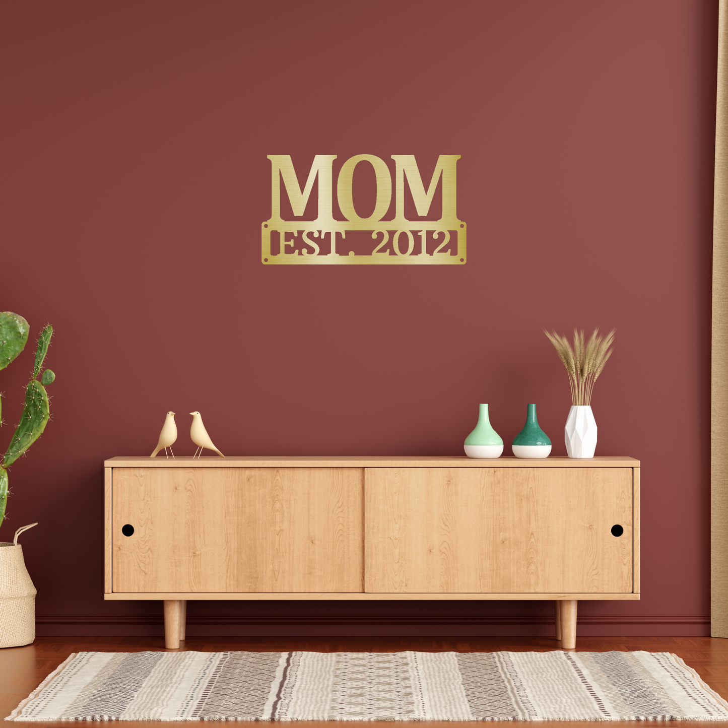 scripted MOM plaque with personalized  date of motherhood, powder coated gold finish metal wall decor, hanging on a rusty red accent wall over a wooden cabinet | Home Accent Studio