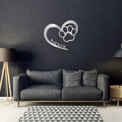 an open heart with a paw print in it, and personalized with a name, powder coat silver finish metal wall decor, hanging on a black wall over a black sofa | Home Accent Studio